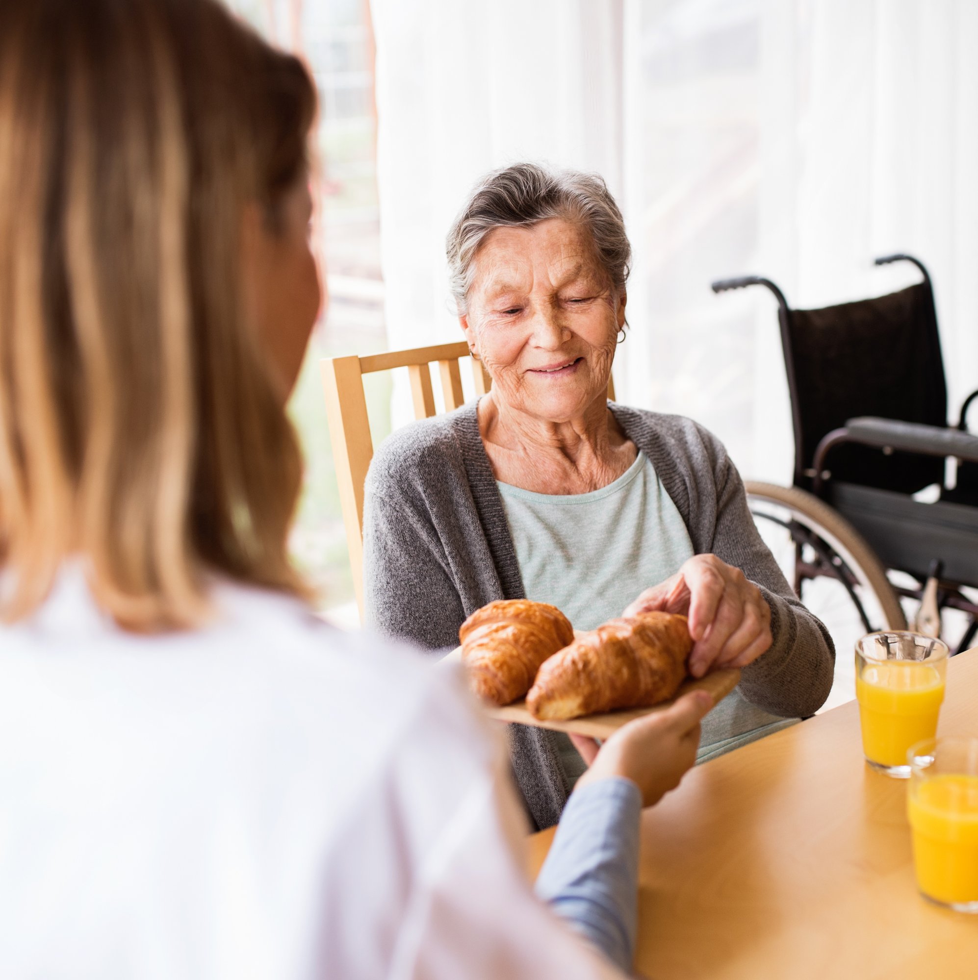elderly woman reaching for a piece of bread elderly woman reaching for a piece of bread